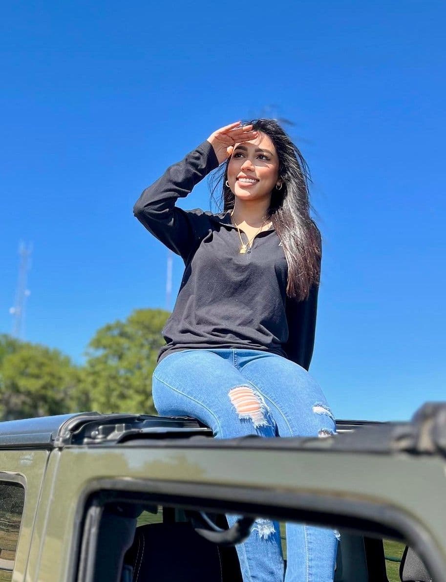A pic of adventurous Layla sitting on her fav possession: a 2017 Jeep Wrangler.